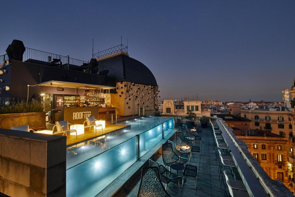 Rooftop avec piscine en verre et vue sur Barcelone de nuit Hotel Ohla Barcelona